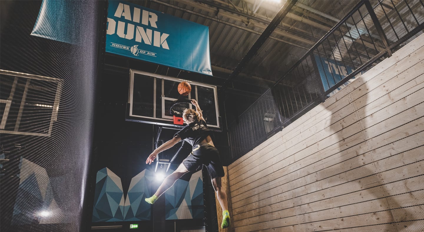 young adult jumping and dunking ball in hoop