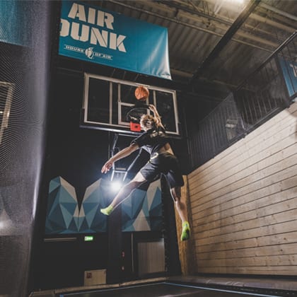 young adult slam dunks ball in the hoop