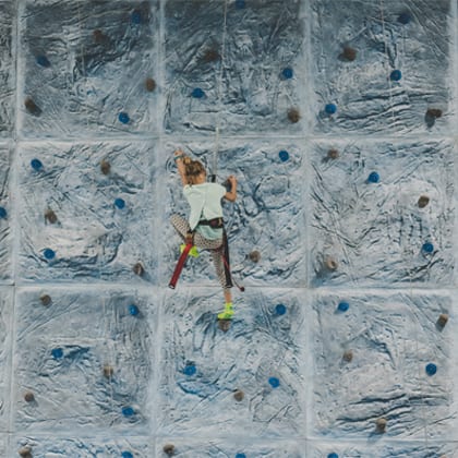young lady climbing the climbing wall at HOA