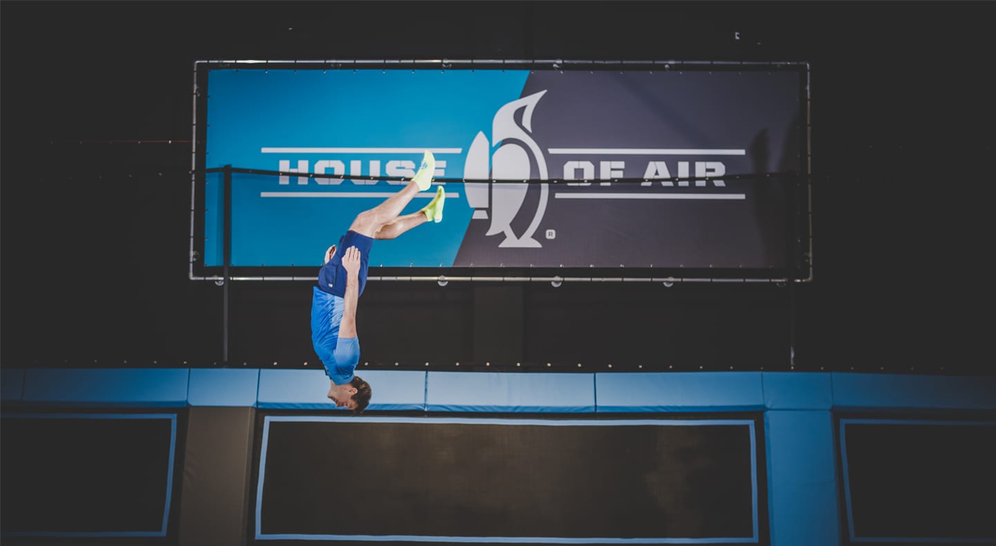 man jumps in front of house of air