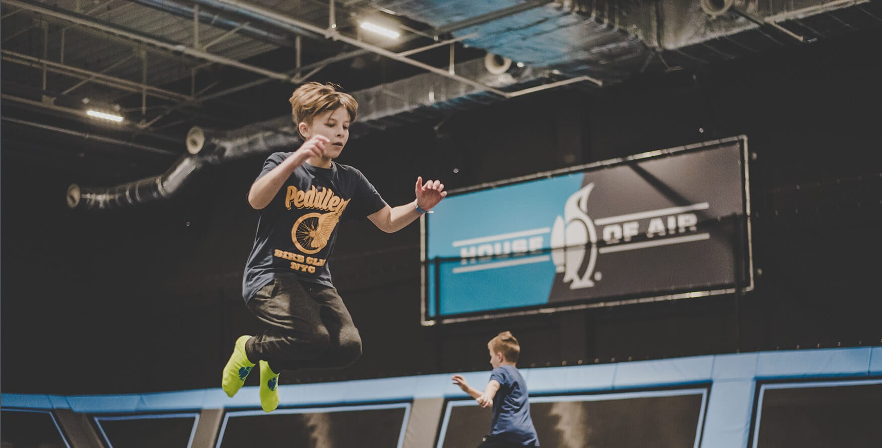 young teenager bounces on the main floor of house of air